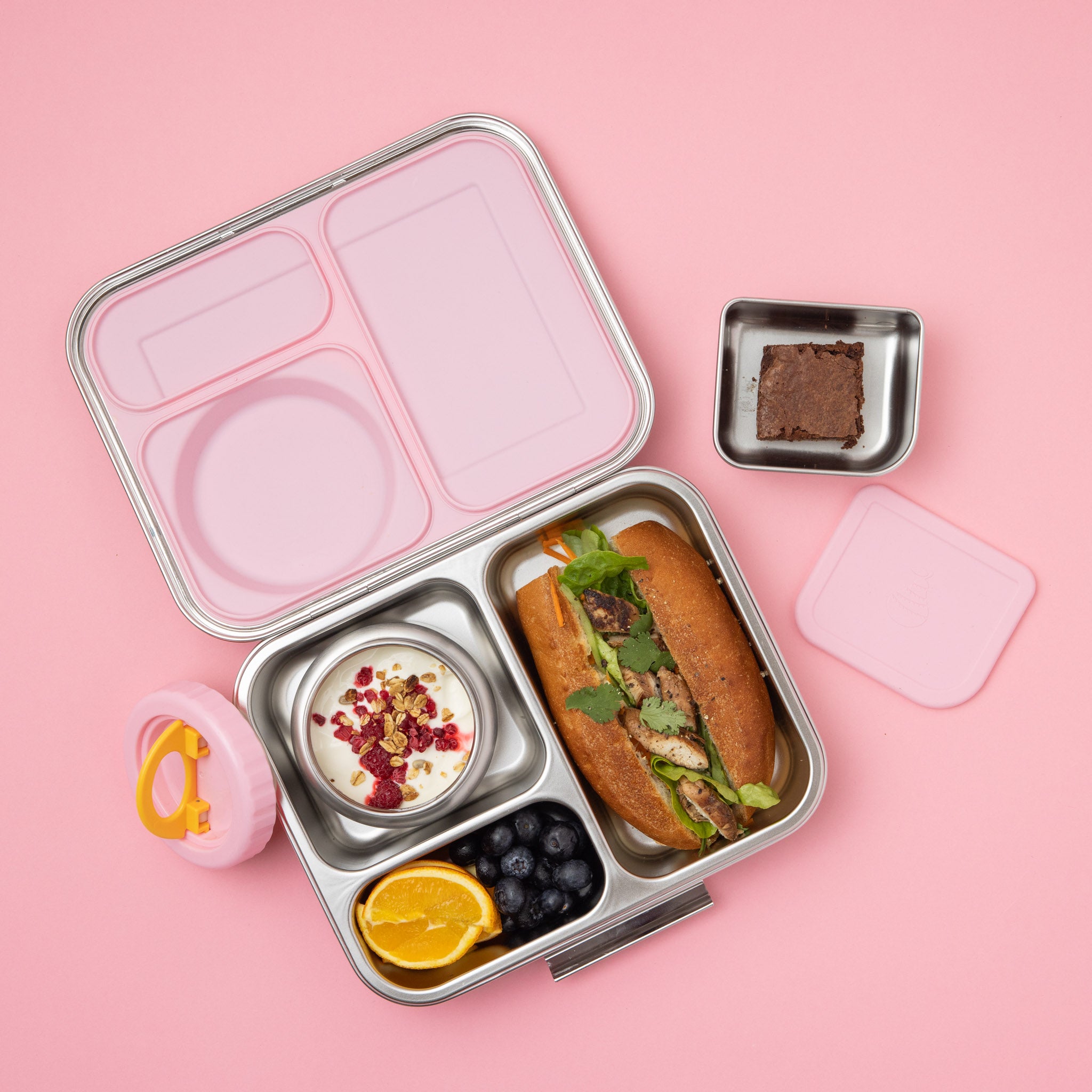 stainless steel 3 compartment bento box with light pink silicone seal and insulated food jar plus snack container filled with a variety of food